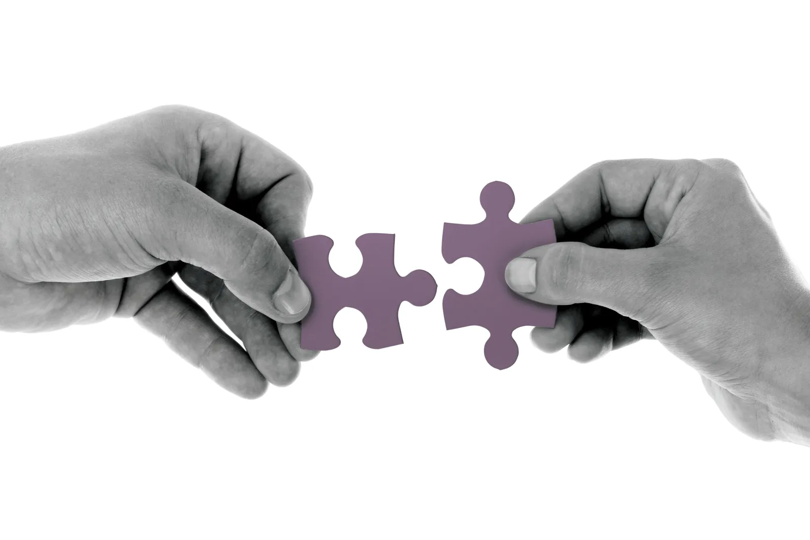 Two hands joining jigsaw pieces